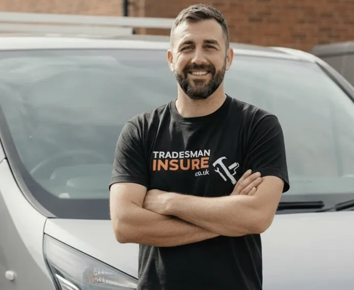 Tradesman in a TradesmanInsure t-shirt standing with arms folded in front of his van